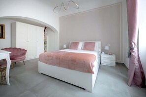 Une chambre à coucher comprenant un lit, un bureau, une chaise, une armoire et une table de chevet.