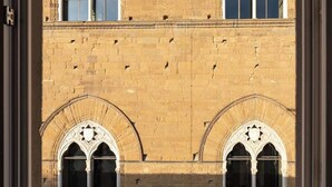 Un bâtiment doté de trois fenêtres en arc et d’une façade en briques.