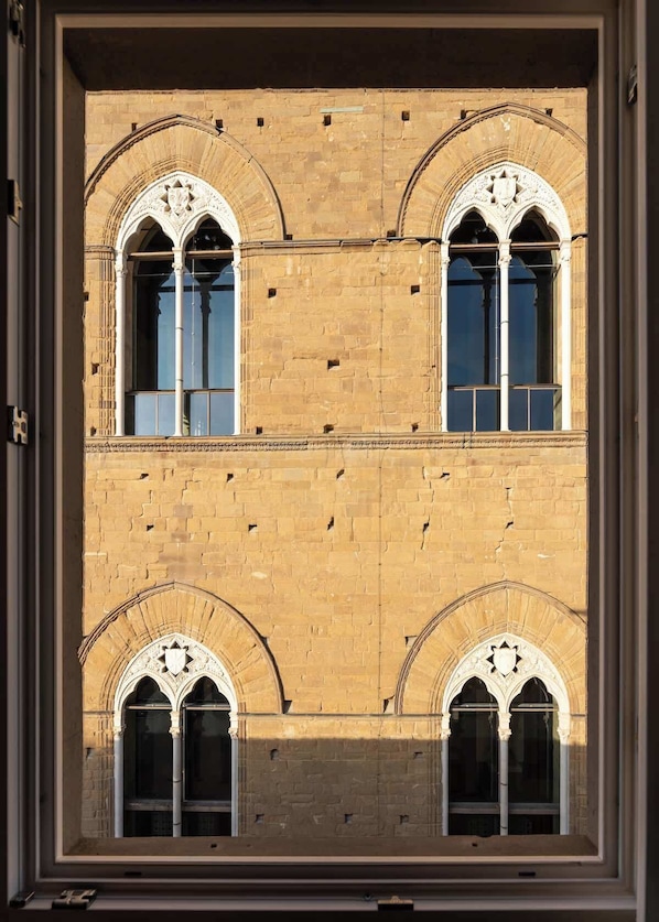 Un edificio con tres ventanas de arco y fachada de ladrillo.
