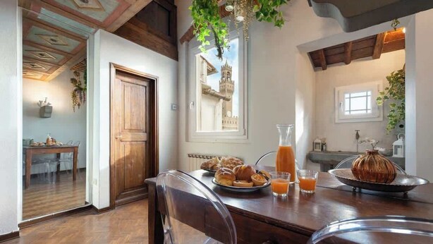 Un coin repas avec une table en bois, des chaises et des aliments pour le petit-déjeuner.