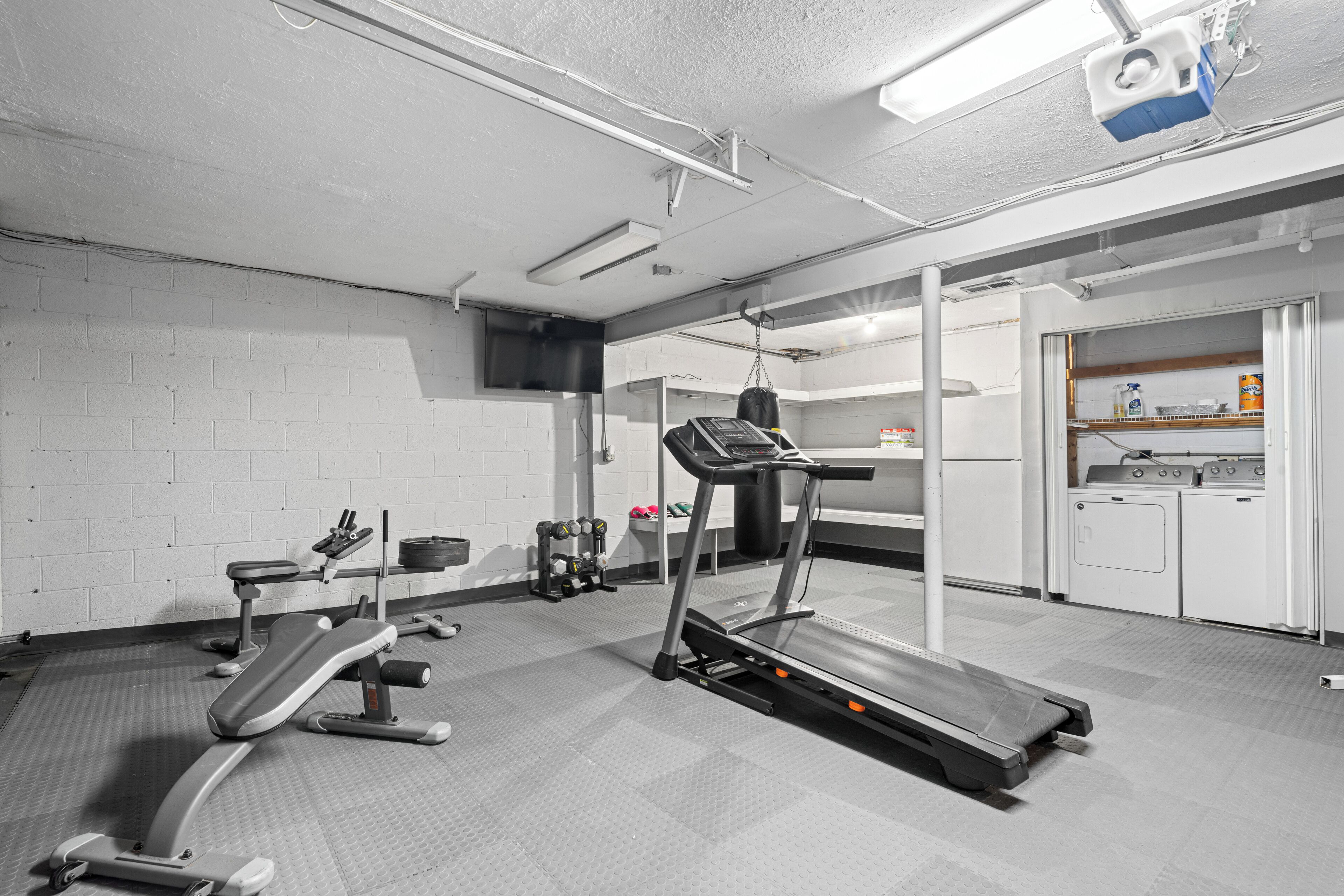 Una palestra con tapis roulant, panche per pesi e attrezzature per esercizi.