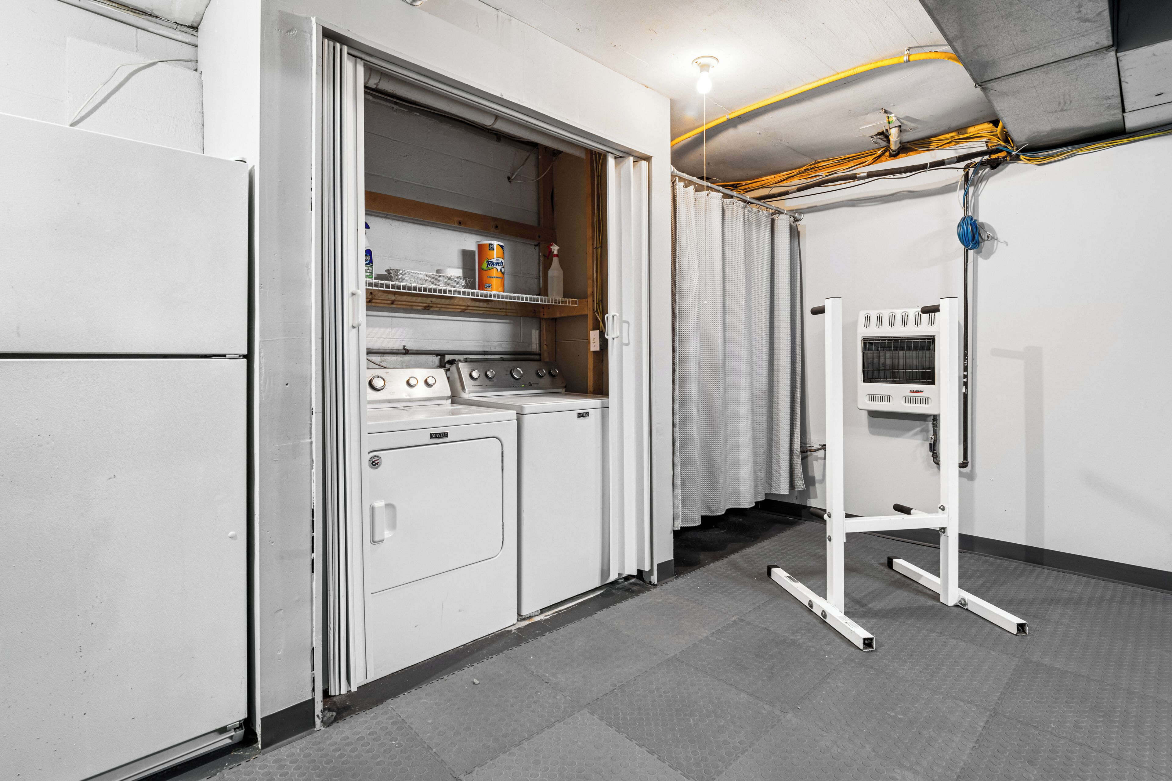 Een functionele keuken met een koelkast, fornuis en wasmachine.