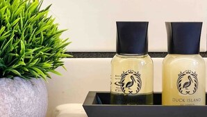 Two bottles of Duck Island skincare products on a black tray.