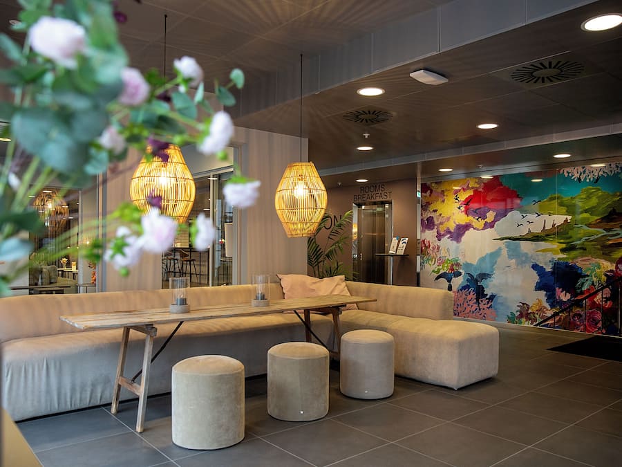 Un vestíbulo moderno con área de estar, una mesa de comedor y un mural en la pared.
