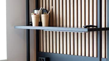 Un espacio de trabajo moderno con escritorio, silla y estanterías frente a una pared de listones de madera.