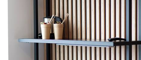A modern workspace with a desk, chair, and shelves against a wooden slat wall.