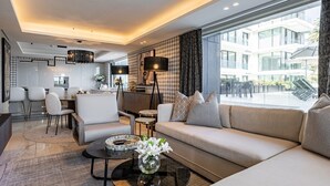 A modern living room with a sofa, coffee table, and dining area. - Aurum 101 (Cape Town)