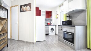 Una cocina moderna con lavadora, microondas y horno.