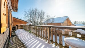 A wooden building with a snow-covered deck and a wooden fence.