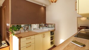 Una cocina moderna con una isla grande, armarios de madera y un espejo amplio sobre el lavamanos.