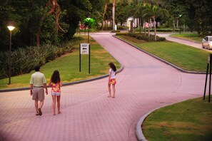 Stroll through a serene urban oasis, lined with lush greenery and a neatly trimmed lawn.