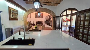 A kitchen with a white countertop, a sink, and a blue cabinet. There is a staircase leading to an upper level. - Luxury Hacienda Home in the Heart of Ajijic
 (Ajijic)