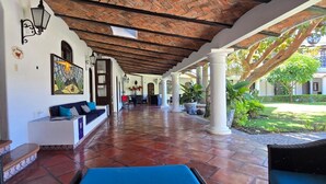 A covered patio with a tiled floor, a sofa, and a dining area. - Luxury Hacienda Home in the Heart of Ajijic
 (Ajijic)