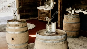 Wooden barrels arranged on a patterned rug in a rustic room with a chandelier, wooden walls, and a vintage aesthetic. - ParkPlaceKeuka FingerLakes: Fab Lake Views,HikingTrails w/TeaHouse on Waterfall! (Branchport)