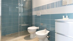 Ein modernes Badezimmer mit Duschkabine aus Glas, Toilette und Bidet.