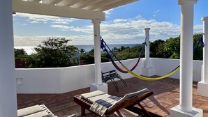 A covered outdoor seating area with a view of the ocean, a hammock, and lounge chairs. - Christmas Deal!Oceanview private pool villa, steps from the beach. 24hs security (Playa del Carmen)