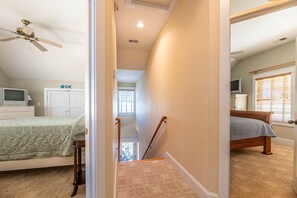A bedroom with a bed, a TV, a ceiling fan, and a window with blinds. - Pirates Hideout - Nags Head MP 10, Ocean View, Pool, Tiki Bar, Fenced Yard, Pets OK, Flex Stays (Nags Head)