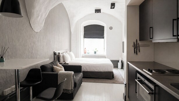 A modern bedroom with a bed, a desk, and a kitchenette. - Guldgränd  (Stockholm)