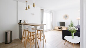 A modern living room with a dining area, a TV, and a sofa. - Modern and cosy apartment with a beautiful terrace and parking, Paris La Défense (Courbevoie)