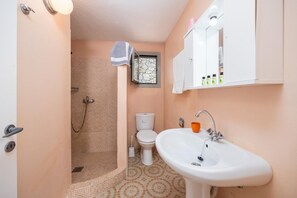 Ein Badezimmer mit Dusche, Toilette, Waschbecken und einem Handtuch an der Wand.