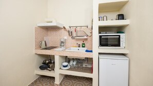 A compact kitchen with a microwave, coffee maker, and basic utensils. - Eleni Cottage - One Bedroom Apartment, Sleeps 2 (Paxi)