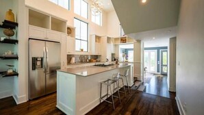 A modern kitchen with a central island, stainless steel appliances, and a bar area.