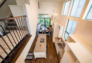 Un interior moderno con una escalera, un comedor y una cocina.