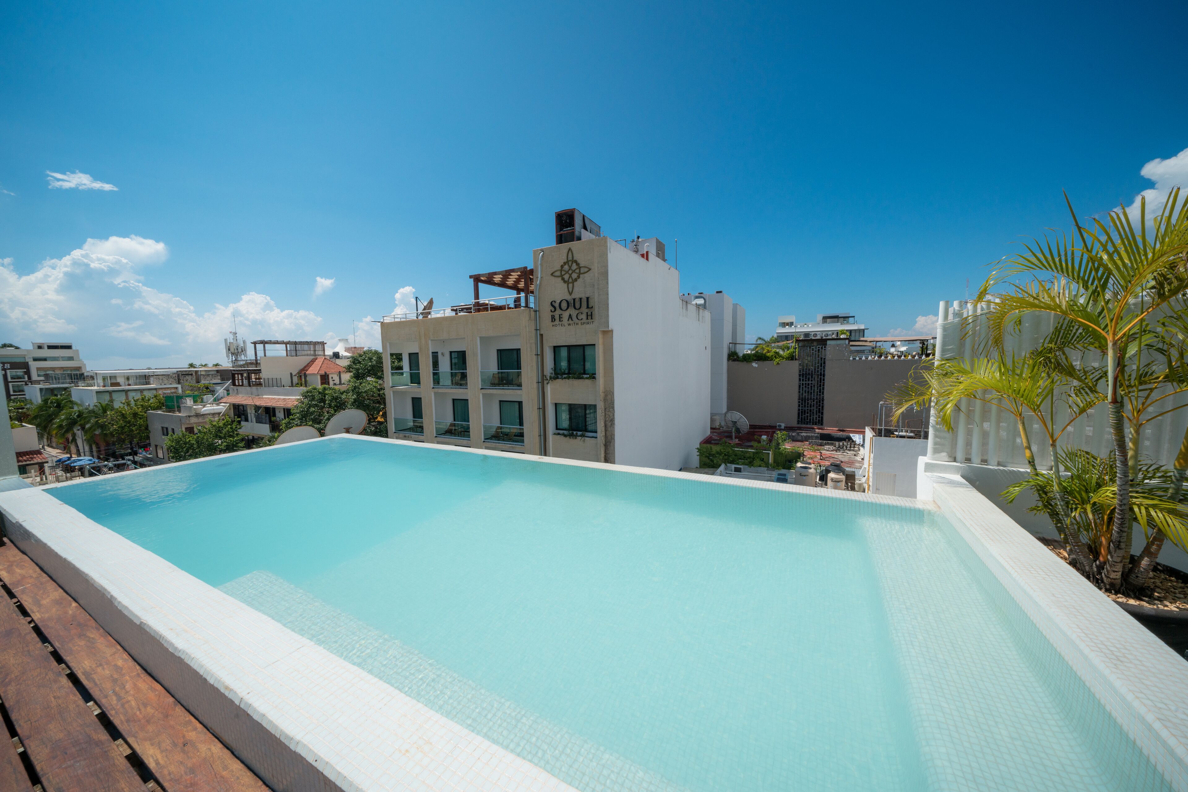 Una piscina sul tetto con vista su un edificio con la scritta "SOUL BEACH" sullo sfondo.
