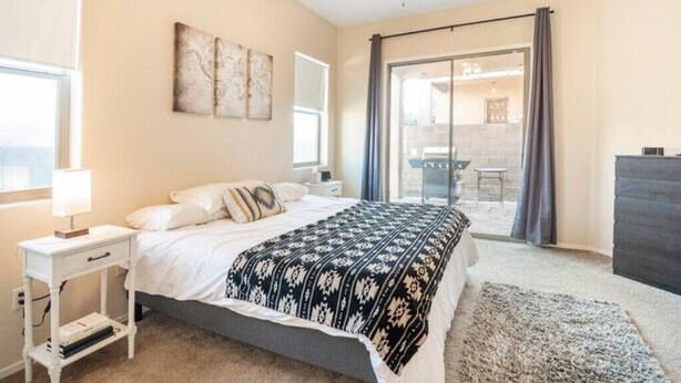 Een slaapkamer met een bed, nachtkastje en plafondventilator.