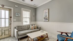 A living room with a grey sofa, a coffee table, and a blue armchair.