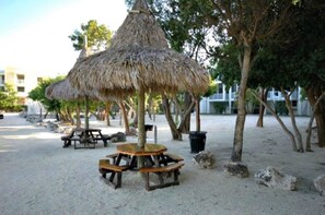 Relax under the shade of thatched umbrellas and enjoy a meal at one of the wooden picnic tables.
