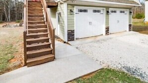 A two-story house with a front staircase, a garage with two doors, and a covered porch.