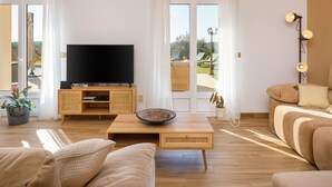 A modern living room with a flat-screen TV, a coffee table, and a sofa. - LE VERGER ALGARVE VILLA (Estói)