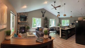 Amplia sala de estar con chimenea de piedra, televisor de pantalla plana y un acogedor conjunto de asientos.