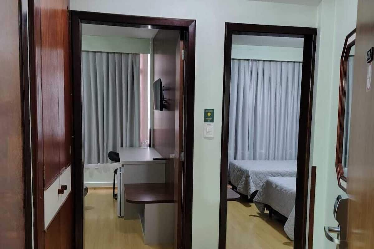 Minibar, escritorio, cortinas blackout y tabla de planchar con plancha 