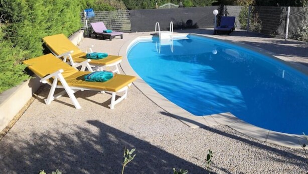 A swimming pool with three sun loungers, a ladder, and a fence. - Beautifull house with swimmingpool in Dordogne (Allemans)
