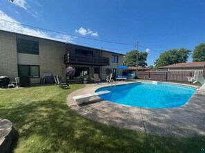 A backyard with a swimming pool, a barbecue area, and a fenced yard. - Hidden oasis with northern feel (Cloquet)