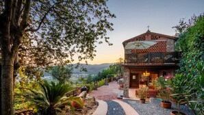 A rustic building with a brick facade, a stone entrance, and a garden with potted plants and a gravel path. - Villa Alice, panoramic stone farmhouse to sleep 10 with pool in Lucca (Lucca)
