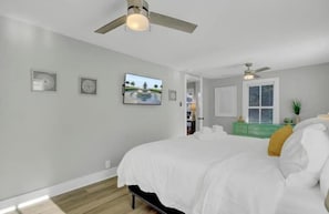 A bedroom with a bed, a ceiling fan, a window, and a green dresser. - Chic Johns Island Cottage w/ King Bed+Smart TVs! (Johns Island)