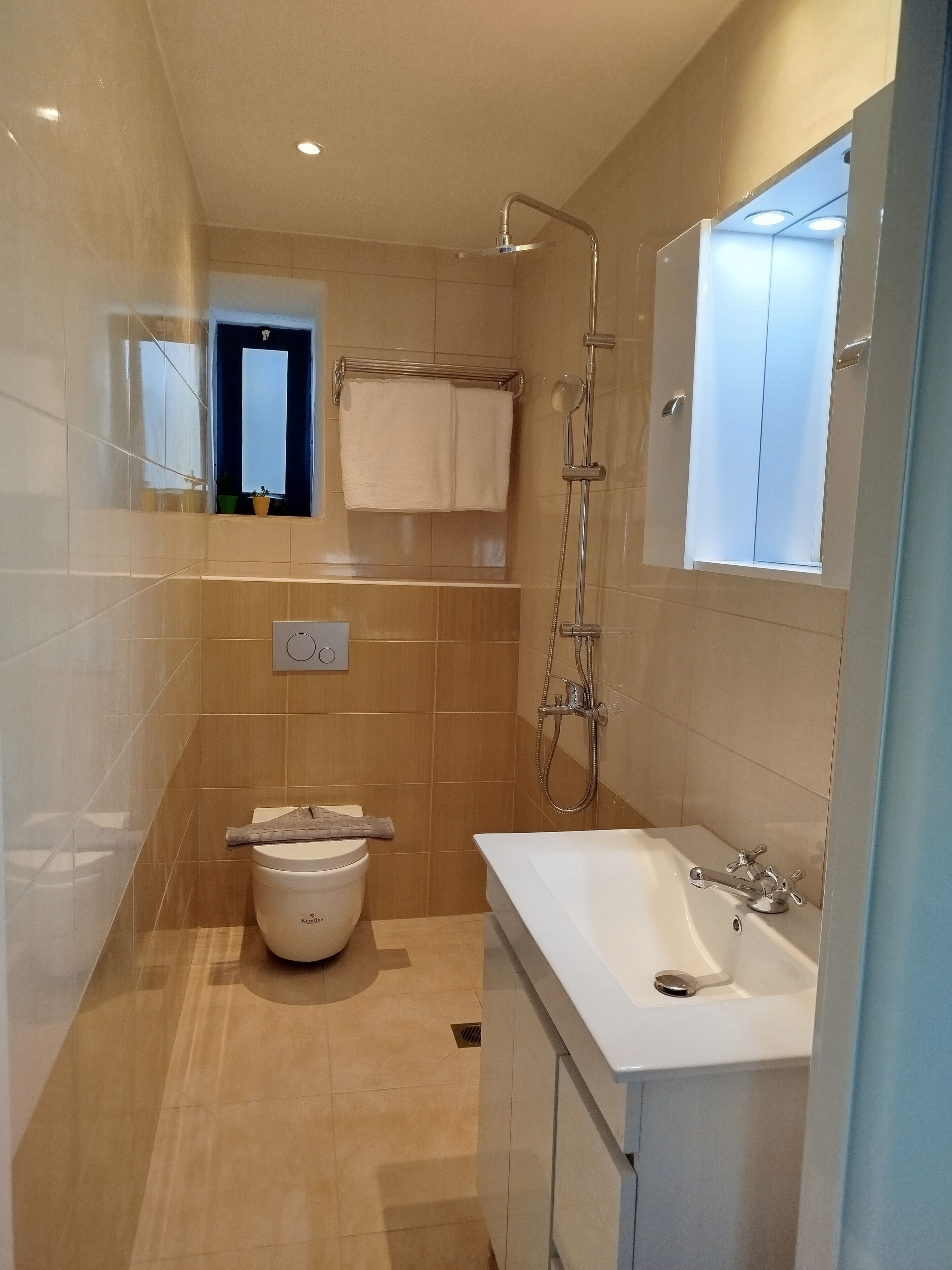 A modern bathroom with a toilet, sink, and shower.