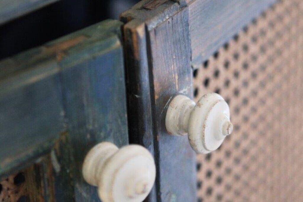 A close-up of a wooden structure with two white knobs, likely part of a piece of furniture or equipment.