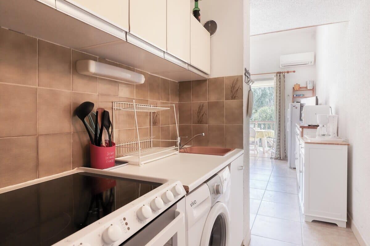 A modern kitchen with a stove, oven, and washing machine.