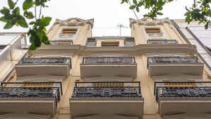 A building facade with multiple balconies, each with ornate metal railings and a beige color scheme. - Nommadas Jero Hotel - Adults Only (Valencia)
