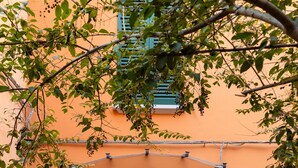 Une porte à deux battants en bois, surmontée d’une plaque portant le numéro « 10 », le tout adossé à un mur orange.