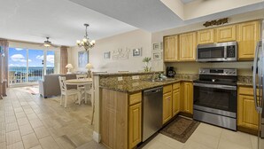 A spacious kitchen with wooden cabinets, stainless steel appliances, and a large island. - Ariel Dunes II 803 *Beach views* 3 pools* (miramar beach)