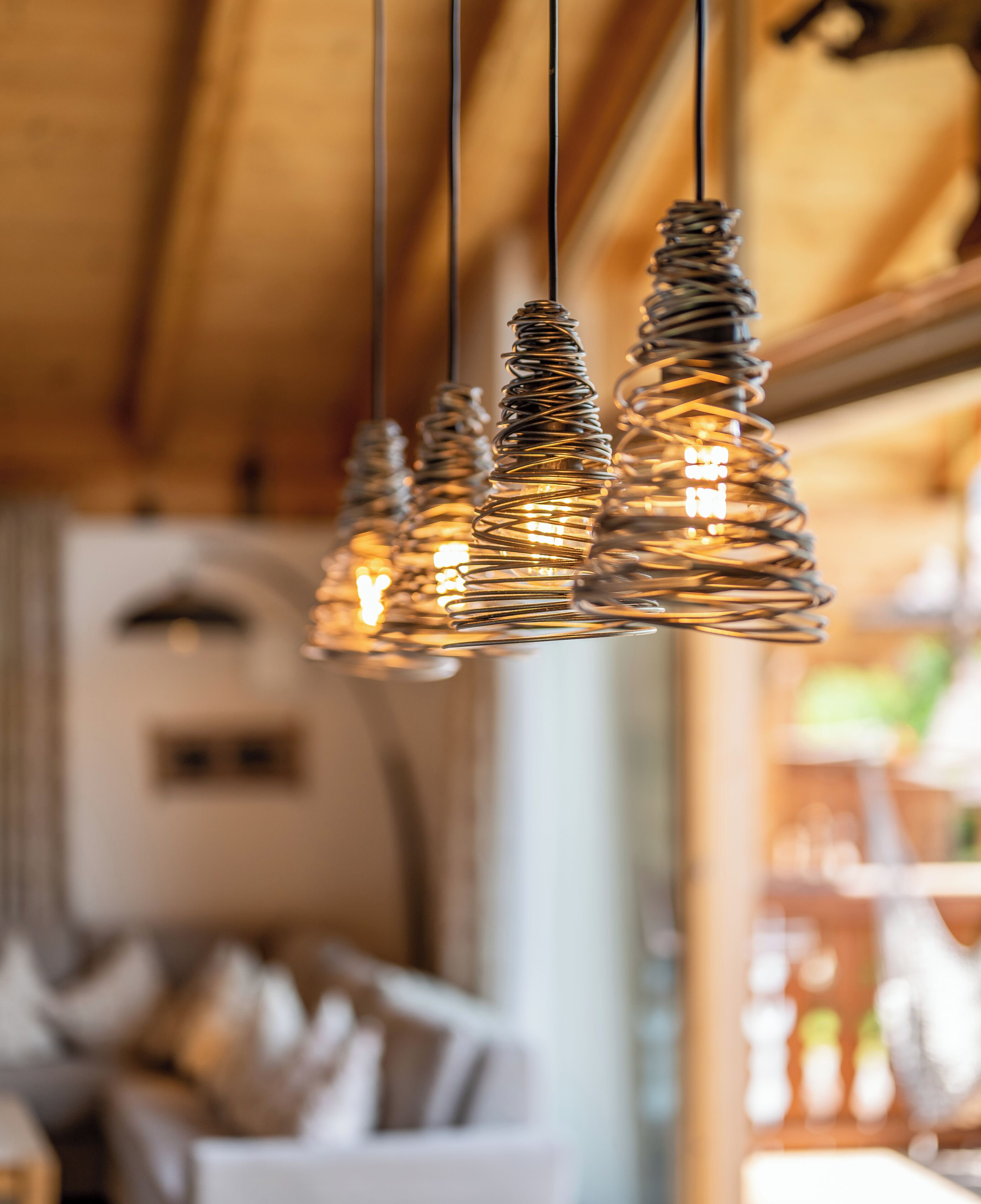 A room with a wooden ceiling and hanging spiral light fixtures.