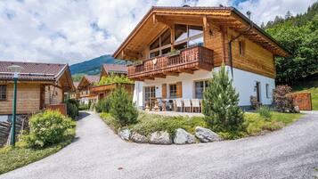 Experience the serene mountain views from the traditional chalet's balcony, surrounded by well-maintained gardens.