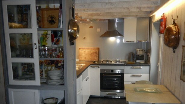 Eine kompakte Küche mit Herd, Backofen und einem Essbereich mit Tisch und Stühlen.