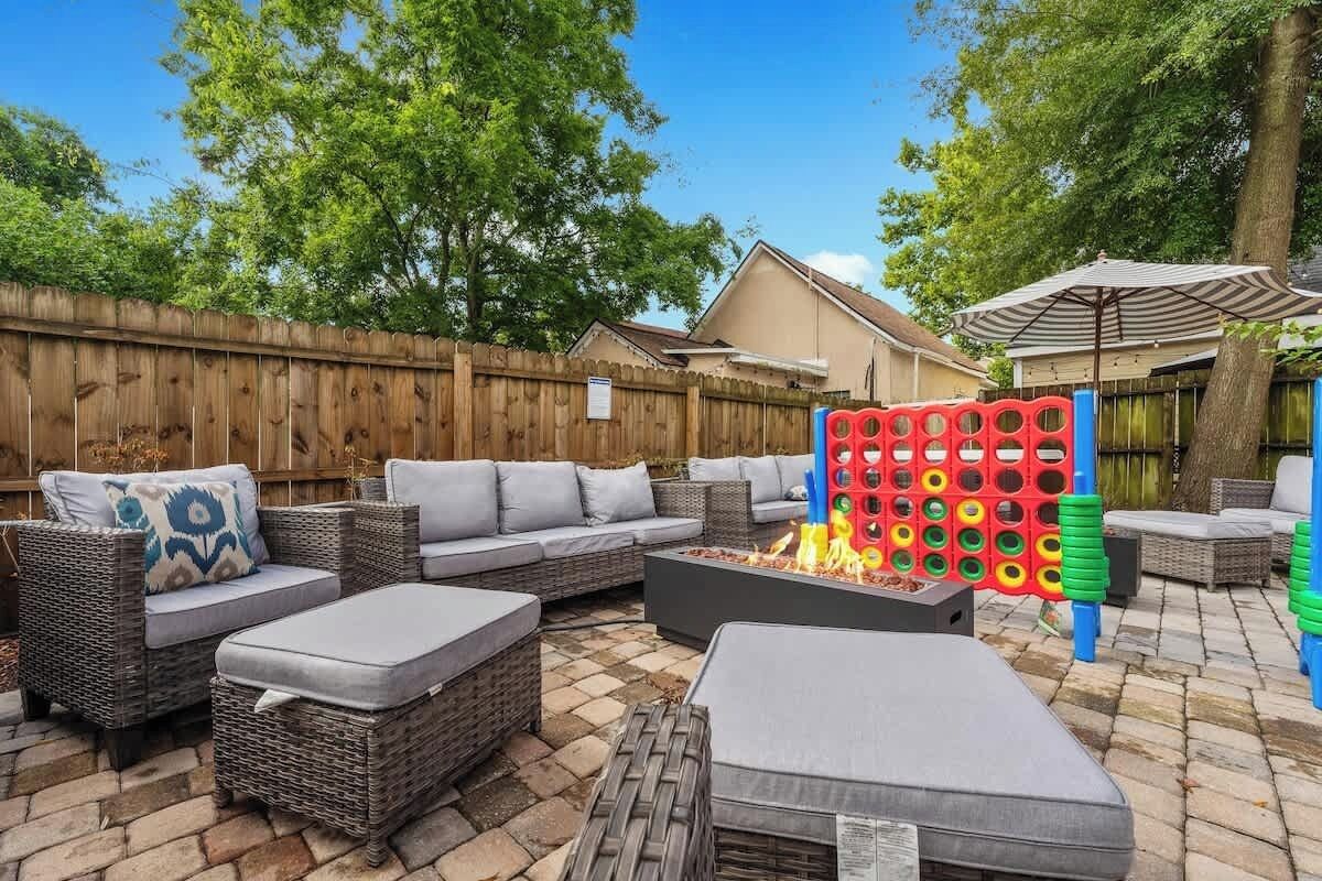 A patio with wicker furniture, a fire pit, and a colorful play structure.