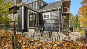 A two-story house with a porch, a chimney, and a staircase leading to a balcony. - Retreat with hot tub, walking distance to town (Douglas)